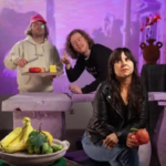 A group of friends posing with fruit in a purple void
